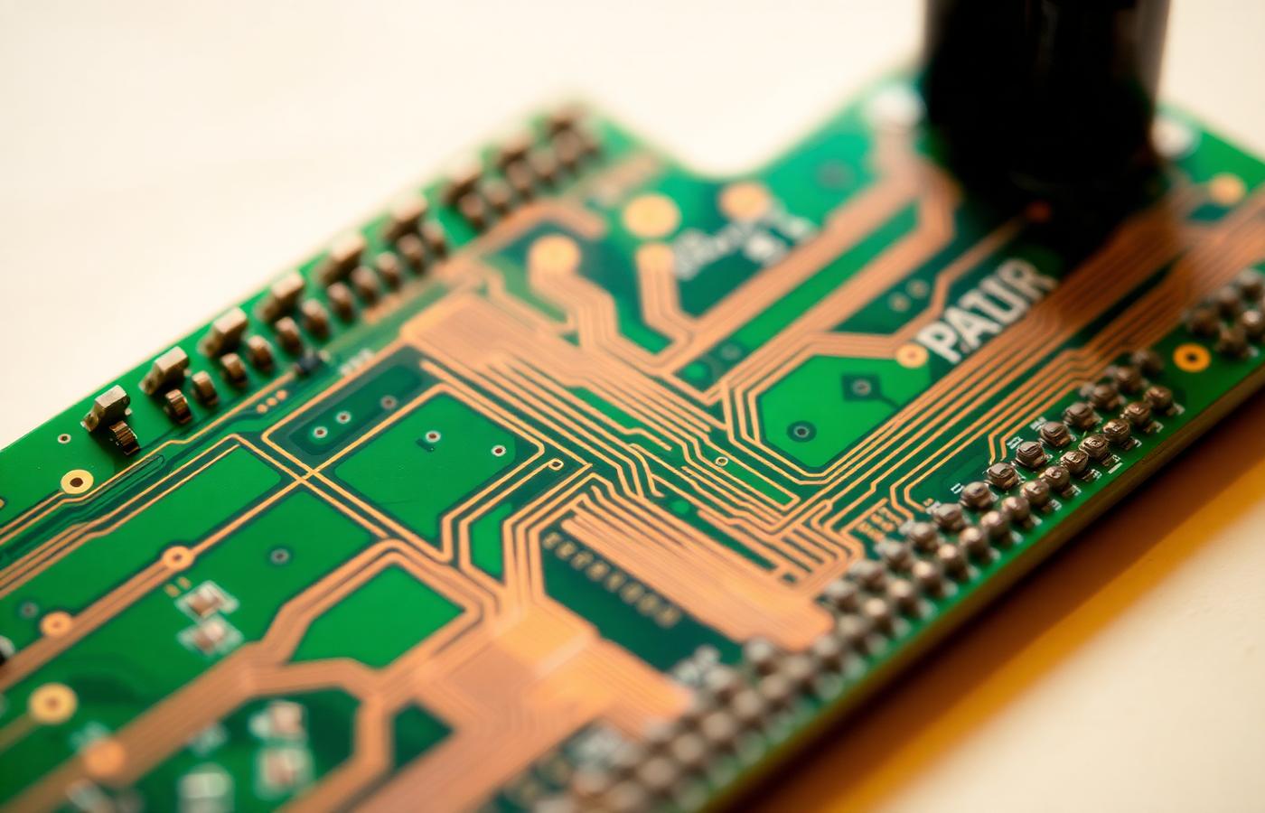 Close-up of copper traces on a green circuit board, illustrating the connections between systems.